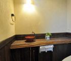 トイレ　和のテイストの朱の手洗い器と無垢板のカウンター